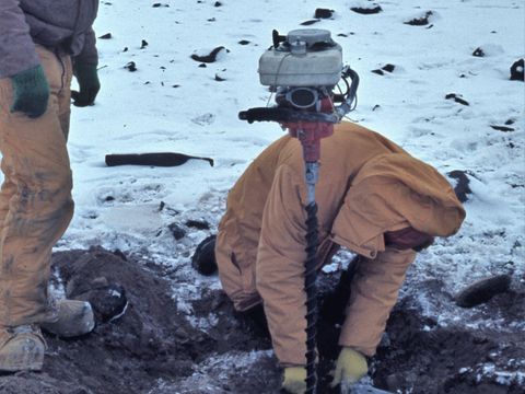 1982-047-G-Claridge-field-assistant-collecting-permafrost-samples.jpg